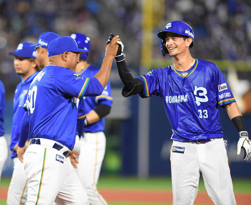 DeNA対中日　サヨナラの犠飛を放った乙坂（右）とタッチするDeNAのラミレス監督（撮影・加藤諒）