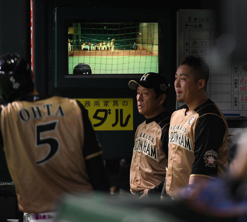得点が取れず、ベンチで渋い表情の栗山監督、右は中田（撮影・今浪浩三）