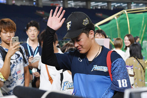 日本ハム対ロッテ　試合前練習を終えファンの声援に手を挙げ応じる日本ハム吉田輝（撮影・滝沢徹郎）