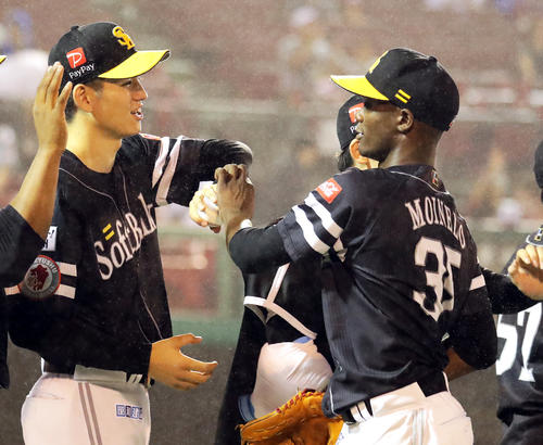 10勝目を挙げた高橋礼（左）にウイニングボールを手渡すモイネロ（撮影・浅見桂子）