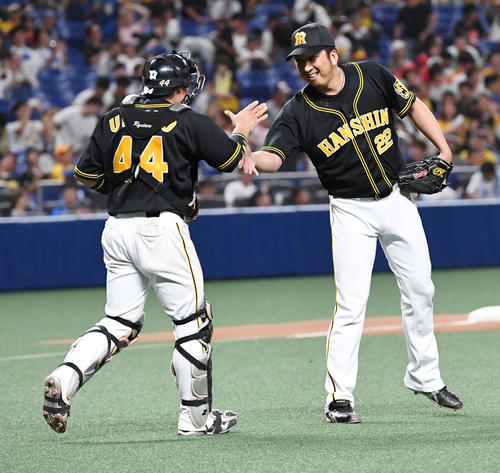 中日対阪神　12回を締めくくり引き分け、笑顔で梅野（左）とタッチする藤川（撮影・前岡正明）