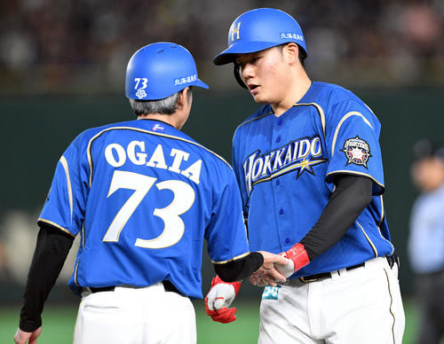 日本ハム対ロッテ　4回裏日本ハム無死、左前打を放った清宮（右）は緒方コーチとタッチを交わす（撮影・滝沢徹郎）
