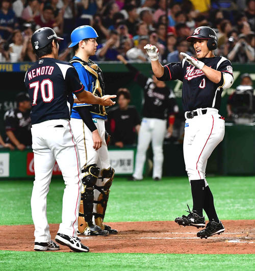 日本ハム対ロッテ　2回表ロッテ2死一塁、荻野（右）は左越えに2打席連続の2点本塁打を放ち根元一塁コーチの祝福を受ける（撮影・小沢裕）