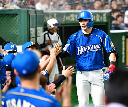 日本ハム対ロッテ　7回裏日本ハム2死、大田は右越えにソロ本塁打を放ちベンチのナインの祝福を受ける（撮影・小沢裕）