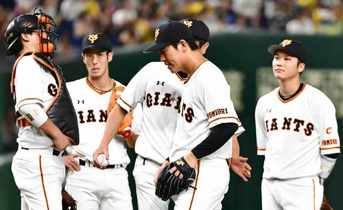 巨人対阪神　7回表阪神1死、降板する巨人先発の桜井（中央）は宮本投手総合コーチに労われる（撮影・小沢裕）