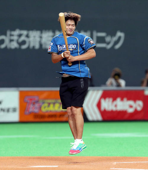 日本ハム対楽天　試合前、ファーストピッチで有森裕子の投じたボールを回転しながら打ち返そうとする小塚崇彦（撮影・佐藤翔太）