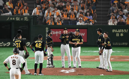 7回途中、降板する阪神能見（中央）はマウンドで福原投手コーチ（右から3人目）らチームメートに声をかけられる（撮影・山崎安昭）