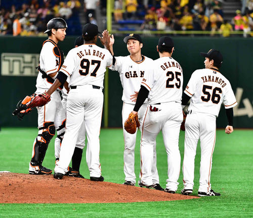巨人対阪神　巨人坂本勇（中央）は歓喜のナインとハイタッチ（撮影・小沢裕）