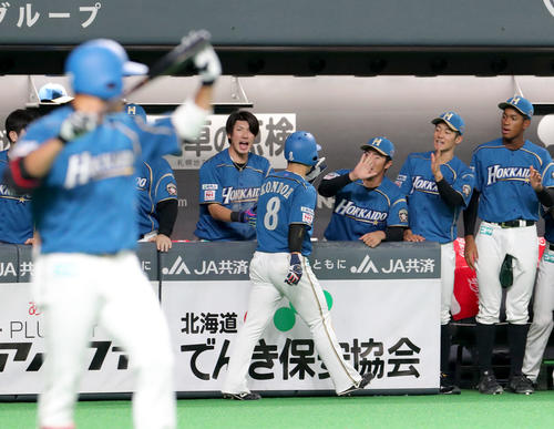 日本ハム対楽天　1回裏日本ハム1死三塁、渡辺の中犠飛で生還しチームメートに出迎えられる近藤（撮影・佐藤翔太）