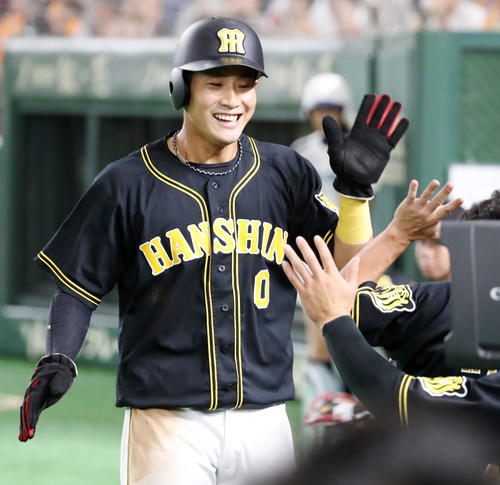 7回表阪神1死二塁、木浪は福留の中前適時打で生還し笑顔でタッチ（撮影・加藤哉）