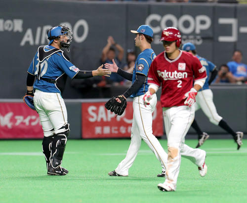 日本ハム対楽天　9回表を無失点に抑えタッチしながらベンチに戻る日本ハム宇佐見（左）と秋吉（撮影・佐藤翔太）
