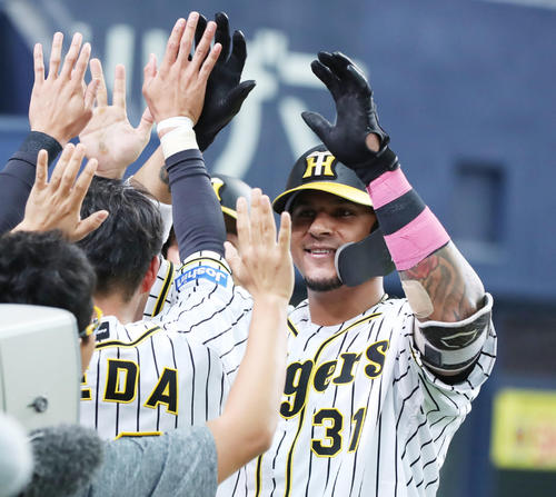 阪神対DeNA　7回裏阪神2死一塁、左越え2点本塁打を放ち、ナインにタッチで迎えられ笑顔を見せるマルテ（撮影・前田充）