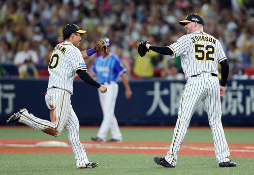 阪神対DeNA　8回表DeNA2死、ソトの打球で好守を見せた遊撃手木浪（左）とタッチを交わすジョンソン（撮影・前田充）