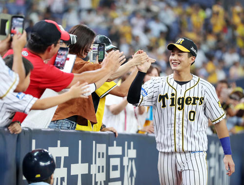 阪神対DeNA　DeNAに勝利し、笑顔で阪神ファンとタッチを交わす木浪（右）（撮影・前田充）
