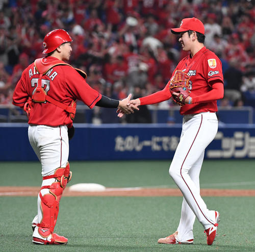 中日対広島　10回を締めくくりプロ初セーブの遠藤（右）は笑顔で会沢と握手（撮影・前岡正明）