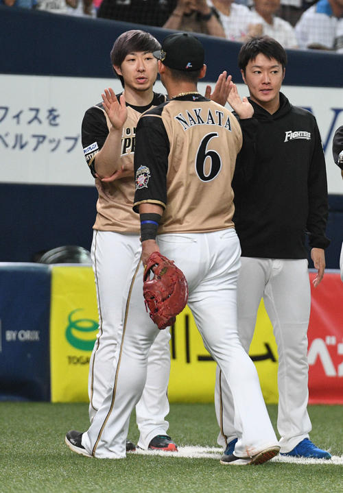 オリックス対日本ハム　5勝目を挙げた金子（左）は復帰戦で2点適時二塁打を放った中田（中央）らとハイタッチ（撮影・渦原淳）