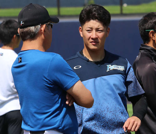 練習中に荒木2軍監督兼投手コーチ（左）の話を聞く日本ハム吉田輝（撮影・山崎純一）