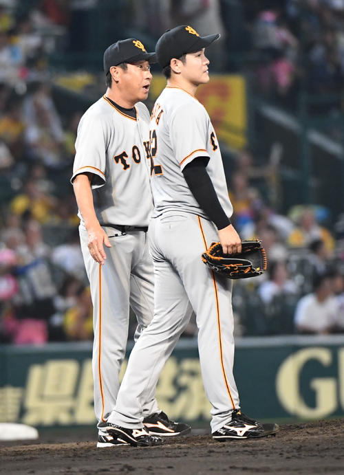 阪神対巨人　5回、鍵谷陽平（右）に交代を告げる宮本コーチ（撮影・奥田泰也）