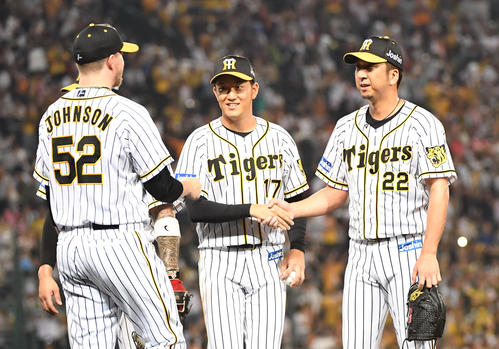 阪神対巨人　勝利投手となった岩貞（中央）は藤川（右）、ジョンソンらと握手を交わす（撮影・奥田泰也）