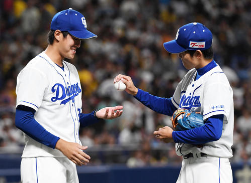 8月12日の中日対阪神　プロ初勝利を挙げた梅津（左）は岡田から勝利球を受け取り笑顔をみせる（撮影・前岡正明）
