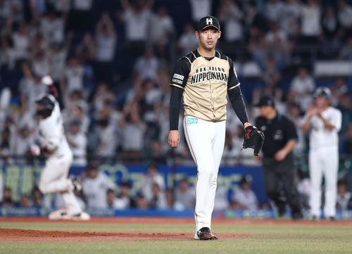 ロッテ対日本ハム　9回裏ロッテ2死一塁、田村（左）に左越えサヨナラ2点本塁打を浴び引き揚げる秋吉（撮影・黒川智章）