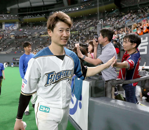 日本ハム対オリックス　試合終了後、ファンとハイタッチをする日本ハム西川（撮影・佐藤翔太）