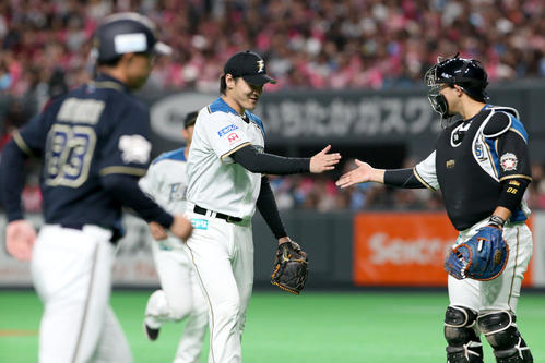 日本ハム対オリックス　タッチを交わしながらベンチに戻る日本ハム有原と宇佐見（右）（撮影・佐藤翔太）