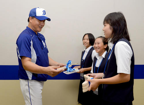 中日対DeNA　試合前、手作りハンガープロジェクトを行っている長野県天龍村の天竜中学校生徒からヒノキを材料に作られたハンガーを笑顔で受け取る与田剛監督（撮影・森本幸一）