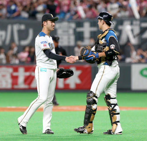 日本ハム対オリックス　試合終了後、握手を交わす日本ハム秋吉と清水（右）（撮影・佐藤翔太）