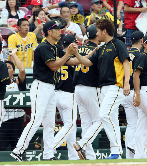 矢野監督（左）と握手を交わす西（撮影・栗木一考）