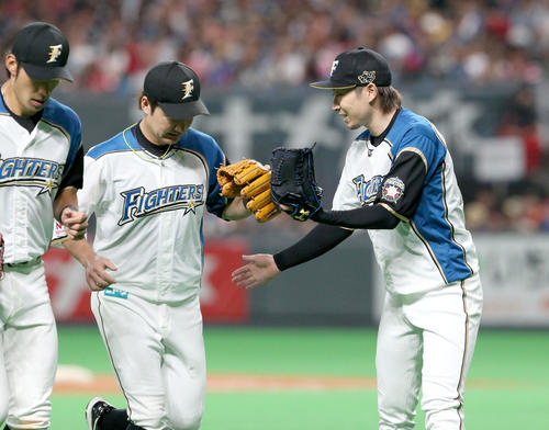 日本ハム対オリックス　6回表オリックス2死一塁、山足を二ゴロに仕留め日本ハム渡辺とタッチを交わしながらベンチに戻る金子（右）（撮影・佐藤翔太）