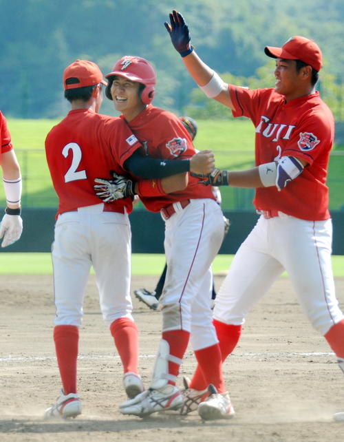 ノースアジア大対富士大　9回裏富士大1死、山田（中央）が左翼越えサヨナラ本塁打を放ち、仲間と喜び合う（撮影・佐々木雄高）