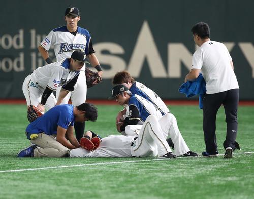 日本ハム対ロッテ　9回表ロッテ無死、レアードの打球を追って渡辺と接触し倒れる中田（撮影・黒川智章）