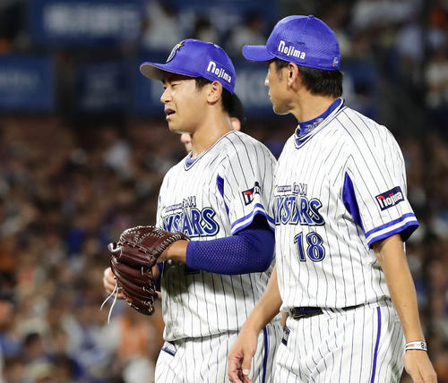 7回表巨人2死、顔をゆがめてベンチへ下がる今永。右は三浦コーチ（撮影・丹羽敏通）