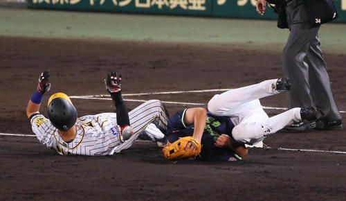 阪神対ヤクルト　4回裏阪神無死、木浪は左翼フェンスに当たる三塁打を放ち滑り込み接触する（撮影・宮崎幸一）