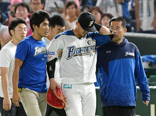日本ハム対ロッテ　9回表ロッテ無死、レアードの打球を追い渡辺と交錯し負傷した中田（手前中央）はベンチへ引き揚げる（撮影・滝沢徹郎）