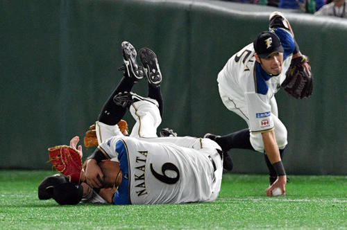 日本ハム対ロッテ　9回表ロッテ無死、レアードの飛球を追って渡辺（奥）と交錯し頭を押さえる中田（手前）。右は大田（撮影・滝沢徹郎）