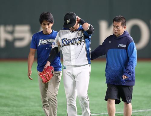 日本ハム対ロッテ　9回表ロッテ無死、レアードの打球を追って渡辺と接触した中田は後頭部を押さえベンチに引き揚げる（撮影・黒川智章）