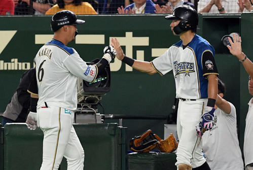 日本ハム対楽天　3回裏日本ハム無死二、三塁、左犠飛を放った中田（左）はベンチへ戻り大田とタッチを交わす（撮影・滝沢徹郎）