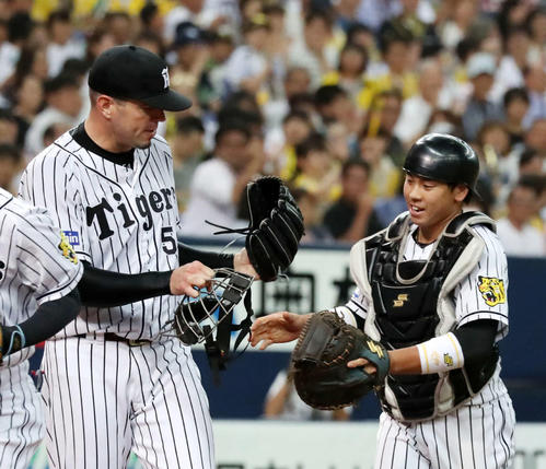 梅野（右）にマスクを渡すメッセンジャー（2017年8月4日）