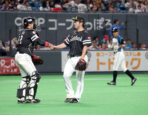 日本ハム対ソフトバンク　試合終了後、握手をするソフトバンク高谷と森。右奥は引き揚げる日本ハム田中賢（撮影・佐藤翔太）