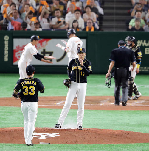 巨人対阪神　3回裏巨人2死、坂本勇（後方）に左翼ソロ本塁打を許し、がっくりの岩貞（撮影・浅見桂子）