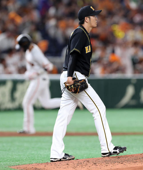 巨人対阪神　3回裏巨人2死、坂本勇（左）にソロ本塁打を浴びスコアボードを見つめる岩貞（撮影・垰建太）