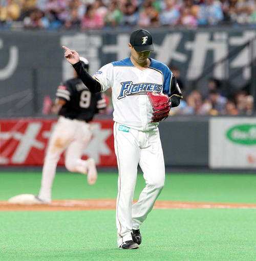 日本ハム対ソフトバンク　5回表ソフトバンク2死二、三塁、柳田（左奥）を遊ゴロに仕留め指差ししながらベンチに戻る日本ハム村田（撮影・佐藤翔太）