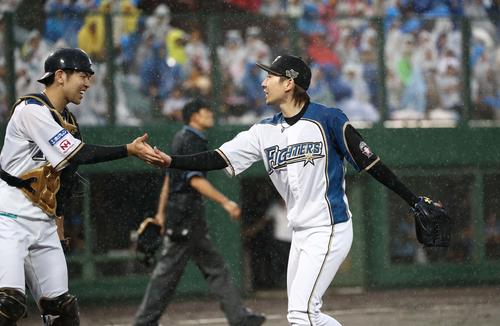 日本ハム対ソフトバンク　7回表、無失点に抑え清水（左）とタッチする金子（撮影・黒川智章）