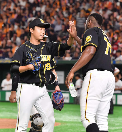巨人対阪神　6回途中から登板した島本浩也（左）は無失点に抑えガルシアとハイタッチする（撮影・上田博志）