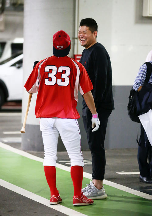 試合が雨天中止となり、球場の駐車場で談笑するDeNA筒香（右）と広島菊池（撮影・足立雅史）