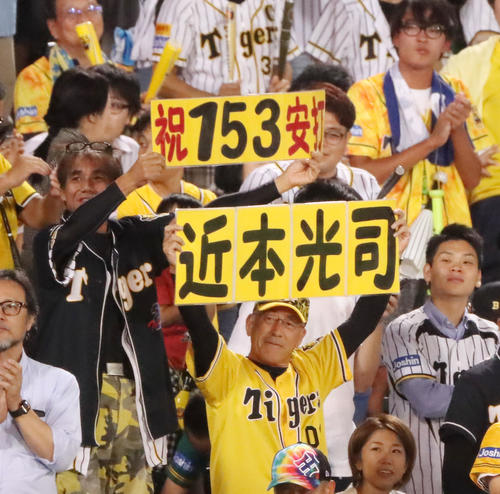 阪神対ヤクルト　8回裏阪神2死、近本が内野安打で153安打を達成し笑顔でボードを持つファン（撮影・加藤哉）