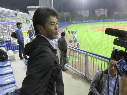 三塁ベンチ前で祝福し合うイスラエルを横目に取材に応じる侍ジャパン稲葉監督