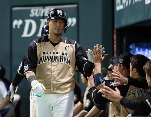 ソフトバンク対日本ハム　9回表日本ハム1死一塁、中田は左中間へ2点本塁打を放ちベンチ前でナインの出迎えを受ける（撮影・栗木一考）